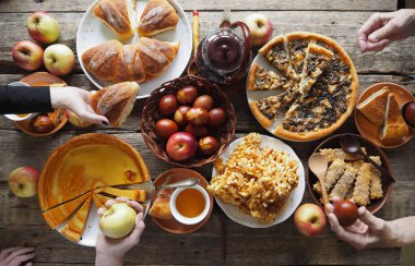 Paskalya arkaplanı. Bayram, Paskalya yemeği, paskalya pastası ve renkli yumurta. Masada yemek yiyen insanların elleri..