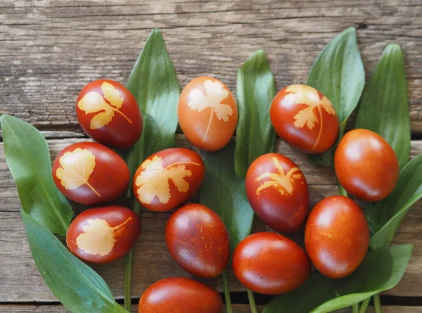 Easter.Colored eggs with a decoction from the onion skin. The traditional method of natural dyeing. Eggs on a plate on a wooden background.Space for text.