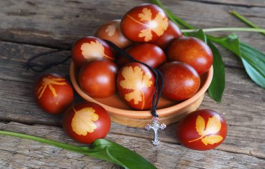 Paskalya. Soğan kabuğundan tütsülenmiş renkli yumurta. Geleneksel doğal boyama yöntemi. Tahta zemindeki bir tabakta yumurtalar. Mesaj için yer var..