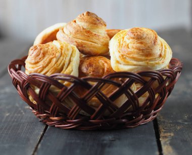 Ev yapımı çörekler, koyu ahşap arka planda asma dolu doğal bir tabakta zengindir. Tatil ve günlük yemek. Yan görünüm.