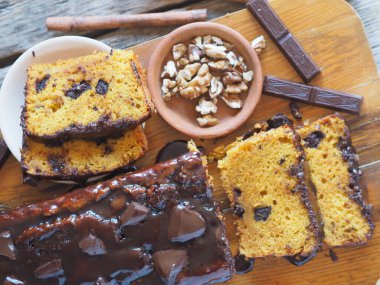 Yakın plan. Tatil balkabağı, uzun dikdörtgen kek, çikolata kaplı, mutfak tahtasında yemeye hazır. Ahşap arka plan..