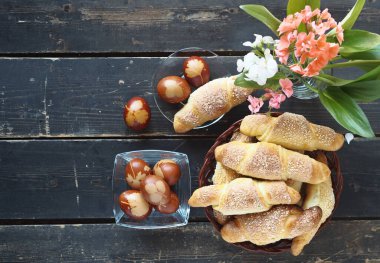 Paskalya arkaplanı, üst manzara. Yumurta boyalı soğan kabuğu ve ev yapımı kekler. Çiçekli, koyu renk ahşap arka planda..