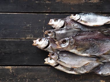 Hava kurutmalı, özel mülkiyetli, tatlı su nehri balık kroketi, koyu ahşap bir masada. Kapat..