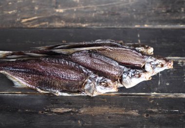Hava kurutmalı, özel mülkiyetli, tatlı su nehri balık kroketi, koyu ahşap bir masada. Kapat..