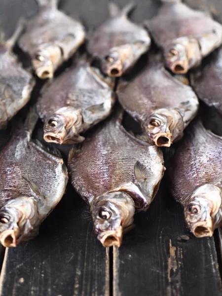 Fish background.A lot of air-dried, salty freshwater bream on a dark wooden ancient table.River fish.