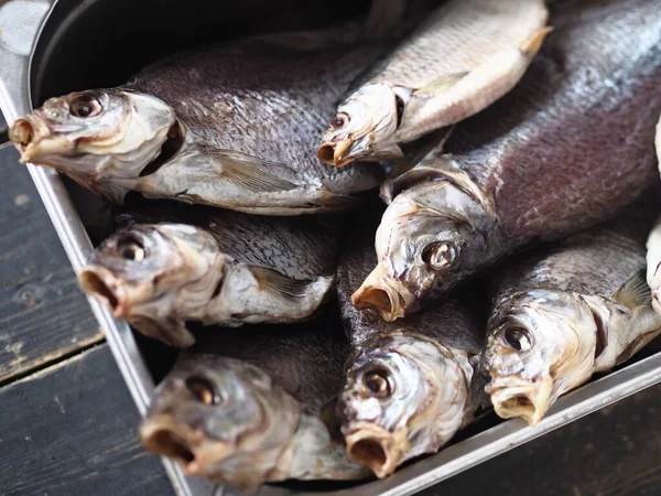 The view from the top.Dried privately, in the fresh air, salted large bream, in a metal container.Close up.River fish.