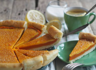 Ev yapımı turtalı peynirli kek ve balkabağı, çırpılmış yumurtaların üzerine serpiştirilmiş, ahşap bir arka planda şeker. Metin için boşluk.