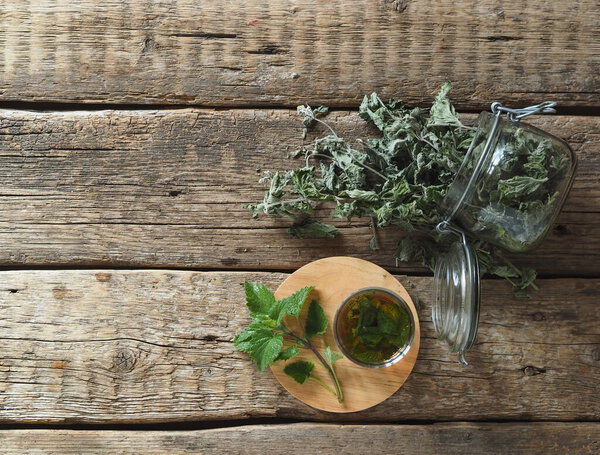 Наркотики. Травяной чай с сушеной Мелиссой или мятой на натуральном деревянном столе
.