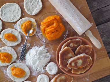 Ev yemeği, aşçılık diyeti, balkabağı arkaplanı. Mutfak tahtasını doldurarak turta yapma süreci..