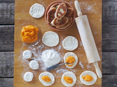 Ev yemeği, aşçılık diyeti, balkabağı arkaplanı. Mutfak tahtasını doldurarak turta yapma süreci..