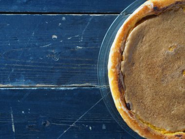 Turuncu kabaklı turta. Koyu ahşap arka planda doğal vejetaryen tatlısı. Üst görünüm, düz biçim.