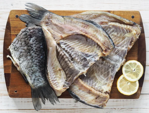 The view from the top.Fish background. Carcasses of freshly salted Russian river fish, ready to eat, on the kitchen cutting Board on a white wooden table.