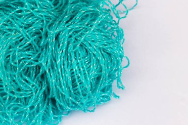 Örgü teması için arka plan. Beyaz bir arkaplanda mavi akrilik iplik yumağı fotokopi alanı ile yakın plan