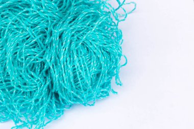 Örgü teması için arka plan. Beyaz bir arkaplanda mavi akrilik iplik yumağı fotokopi alanı ile yakın plan