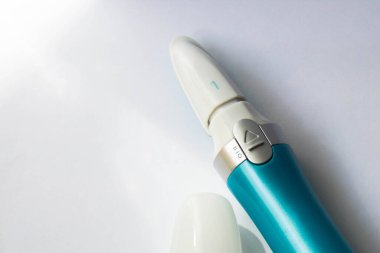 Evde manikür için bir araç. Mavi elektrikli çivi dosyası yerine konulabilir eklenti ile beyaz arka planda elmas kaplama ile yakın plan