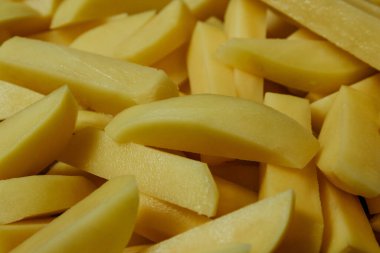 Çiğ patates. Sebze pişiriyorum. Çiğ patates, patates kızartması için dilimlenmiş ve yakın plan pişirme ya da kızartma için hazırlanmış..