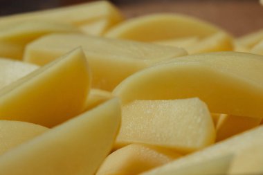 Çiğ patates. Sebze pişiriyorum. Çiğ patates, patates kızartması için dilimlenmiş ve yakın plan pişirme ya da kızartma için hazırlanmış..