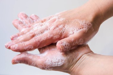Temizlik ve ellerin virüslerden (koronavirüs) ve sabun kullanan bakterilerden korunması. Beyaz arka planda köpüklü sabunlu kadın elleri. Elleri sabunla düzgün yıkama süreci..