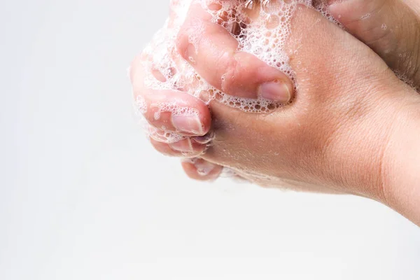 Hygiene and protection of hands from viruses (coronavirus) and bacteria using soap. The process of properly washing hands and fingers with soap foamed with water close-up on a white background