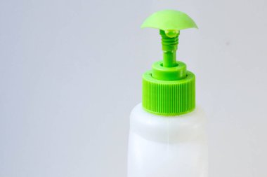 Ellerin virüslerden (koronavirüslerden) ve sabun kullanan bakterilerden korunması. Sıvı antibakteriyel sabunlu, yeşil şeker kutulu plastik beyaz kap. Fotokopi alanı olan beyaz arkaplanı kapat.