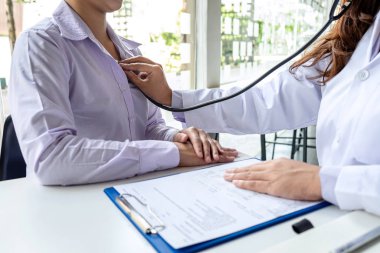 Doktor steteskop kullanarak hastayı kontrol ediyor.