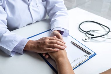 Doktorun eli hastaya dokunuyor. Cesaret vermesi için.