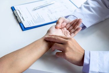 Doktor hastanın el nabzındaki basıncı kontrol ediyor.