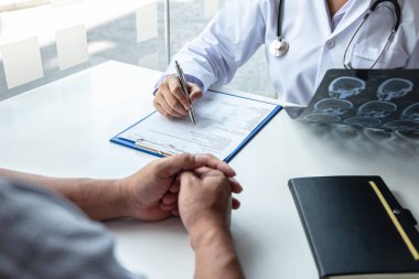 Doctor holding and looking at x-ray film examining at brain by c