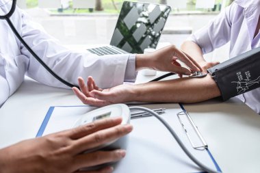Doktor steteskop kullanarak arteryel kan basıncını ölçüyor.