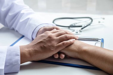 Doktorun eli hastaya dokunuyor. Cesaret vermesi için.