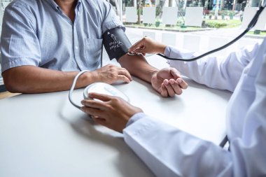 Doktor steteskop kullanarak arteryel kan basıncını ölçüyor.