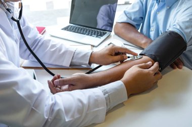 Doktor steteskop kullanarak arteryel kan basıncını ölçüyor.