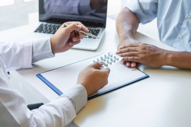 Doktor hasta sunumu ve bir raporun sonuçlarını kontrol ediyor.