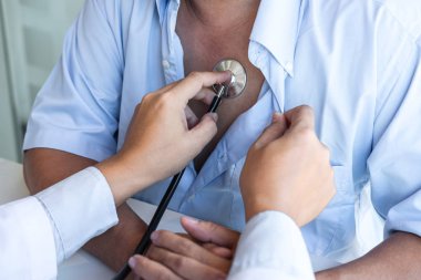Doktor steteskop kullanarak kalp atışlarını ölçüyor.