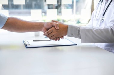Doktor ve hasta iyi ve başarılı bir görevden sonra el sıkışıyor.