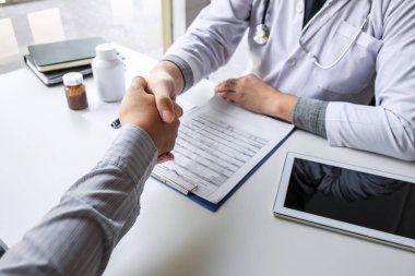 Doktor ve hasta iyi ve başarılı bir görevden sonra el sıkışıyor.