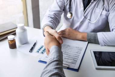 Doktor ve hasta iyi ve başarılı bir görevden sonra el sıkışıyor.