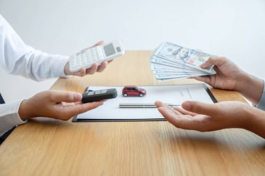 Araba kiralama ve sigorta konsepti, genç pazarlamacı para alıyor.