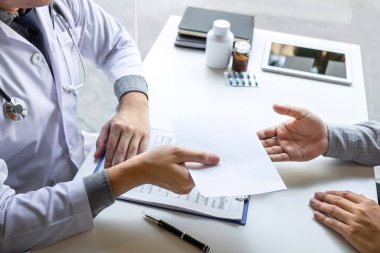 Doktor hasta sunumu ve bir raporun sonuçlarını kontrol ediyor.