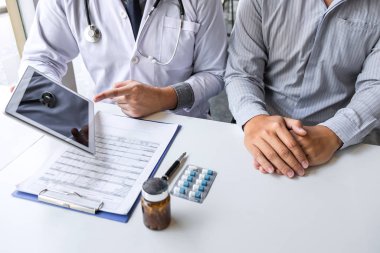 Doktor hasta sunumu ve bir raporun sonuçlarını kontrol ediyor.