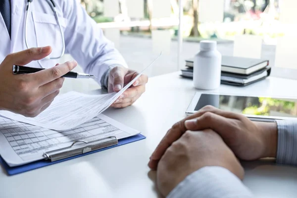 Doctor presenting with patient and checking results on report an — Stock Photo, Image