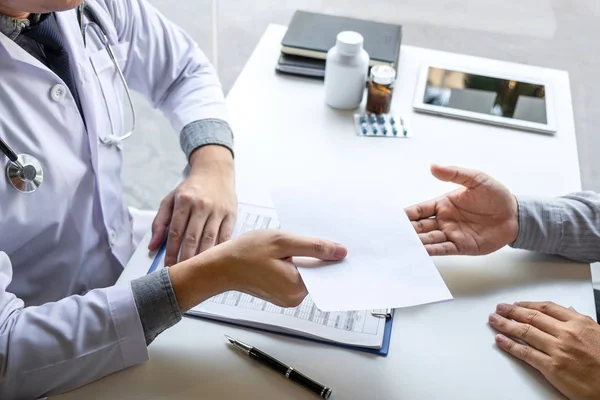 Doctor presenting with patient and checking results on report an — Stock Photo, Image