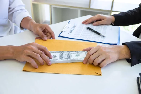 Empresário dando dinheiro de suborno no envelope de seu parceiro — Fotografia de Stock