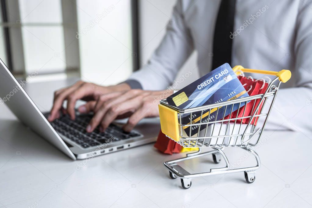Businessman using laptop and holding credit card for paying deta