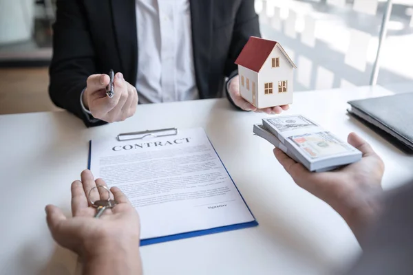 Агент по недвижимости предоставляет ипотечный кредит и дает дом, ключ — стоковое фото