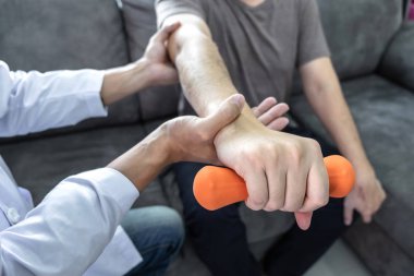 Doktor fizyoterapist kol ağrısı olan hastayı muayene ediyor. 