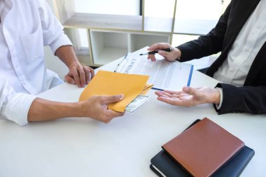 İş adamı, ortağının zarfında rüşvet veriyor. 