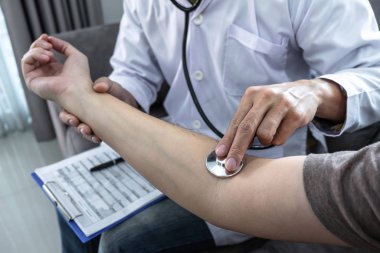 Doktor steteskop kullanarak hastayı kontrol ediyor.