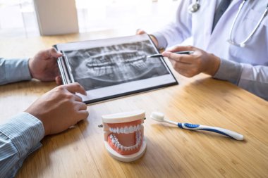 Profesyonel diş hekimi çene ve diş röntgen fotoğrafını gösterir