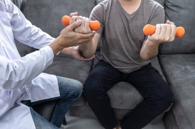 Doktor fizyoterapist kol ağrısı olan hastayı tedavi ediyor. 